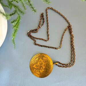 Large round brass pendant with long chain.